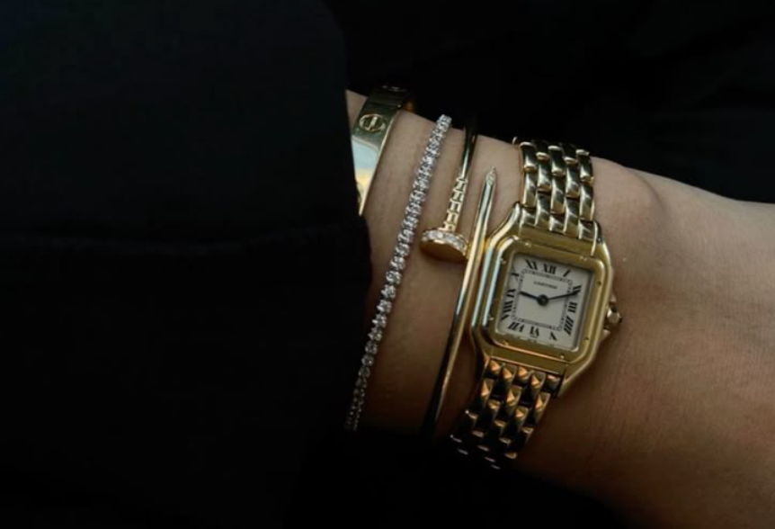 Gold bracelet with luxury watch layering on same wrist - 2025 fashion trend